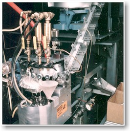 Automated coating line fixturing used for applying sealant to plugs.