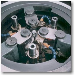 Tri-roll die head with three circular dies positioned around the work piece.